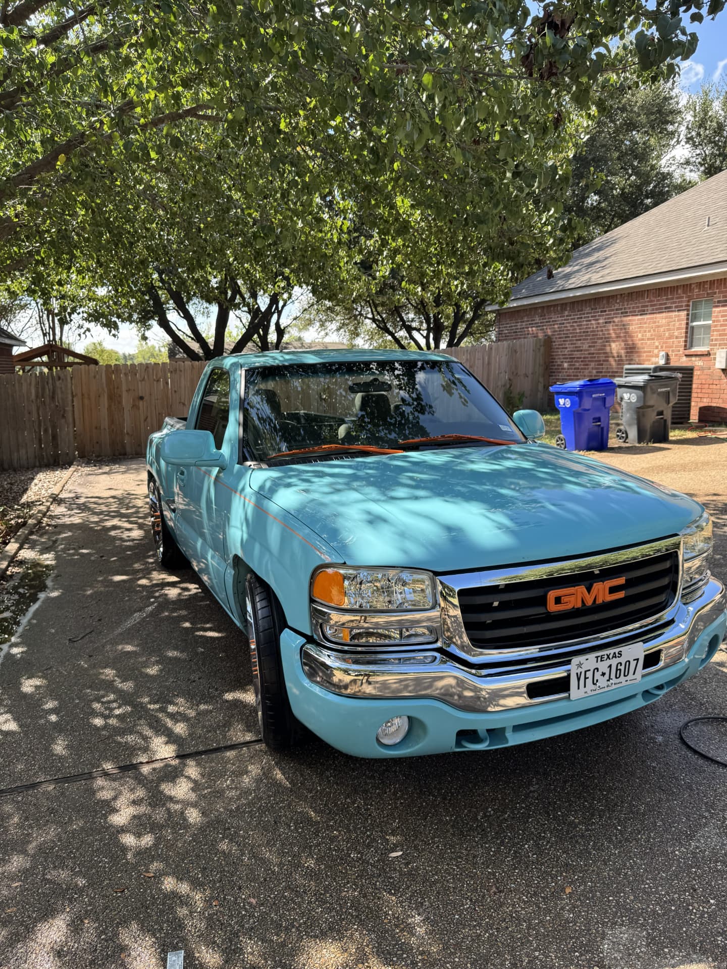 Freshly detailed teal GMC Sierra shining in a Waco driveway