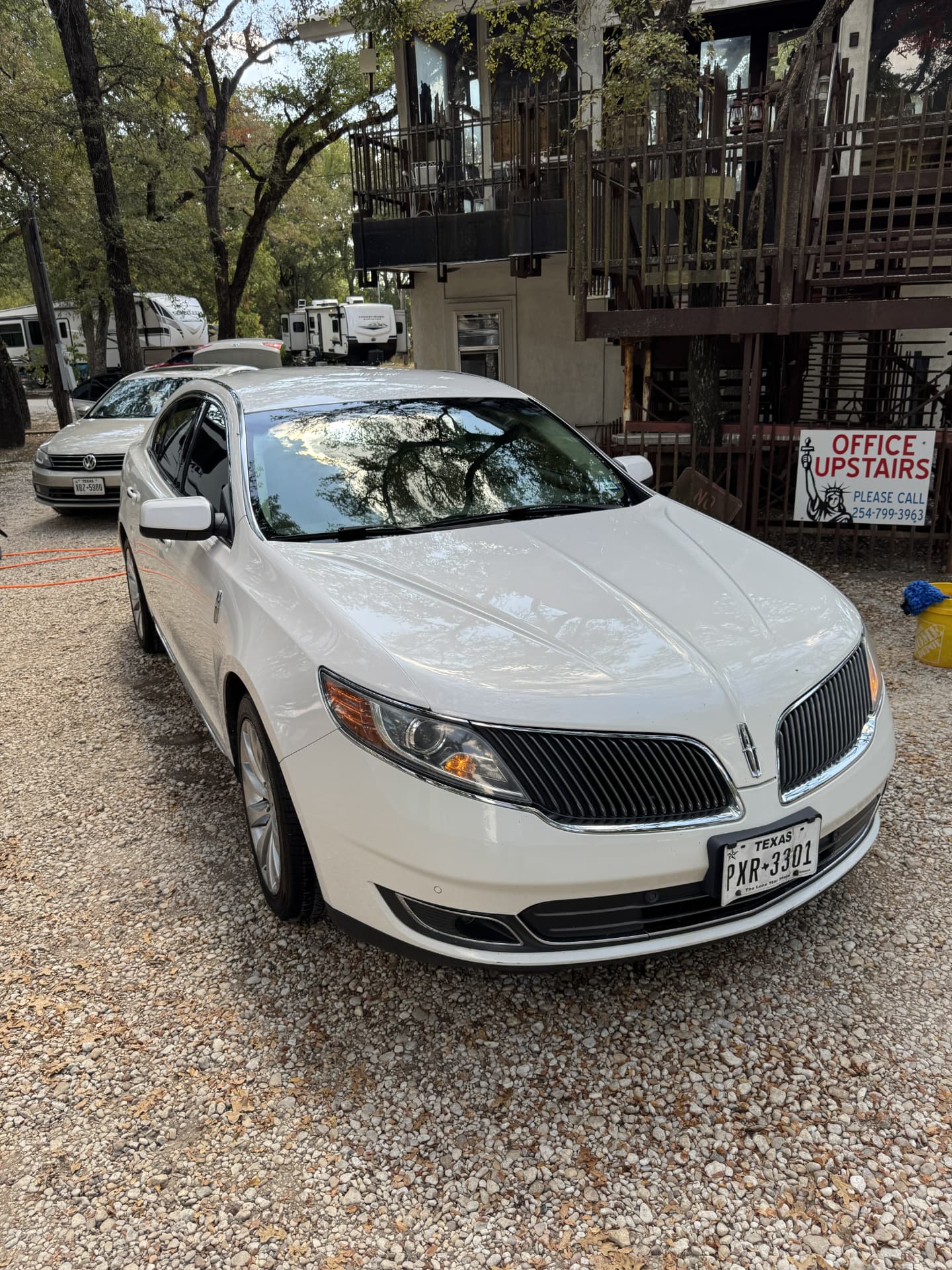 White Lincoln sedan detailed and gleaming on a gravel lot